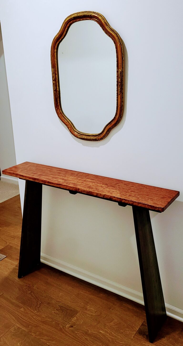Console table beneath wall mirror.  Bubinga and ash woods.  Oil and lacquer finishes.